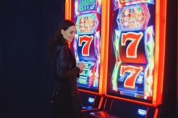 A man celebrating a winning moment on his laptop while gaming symbols float around him, capturing the excitement of A177 games.